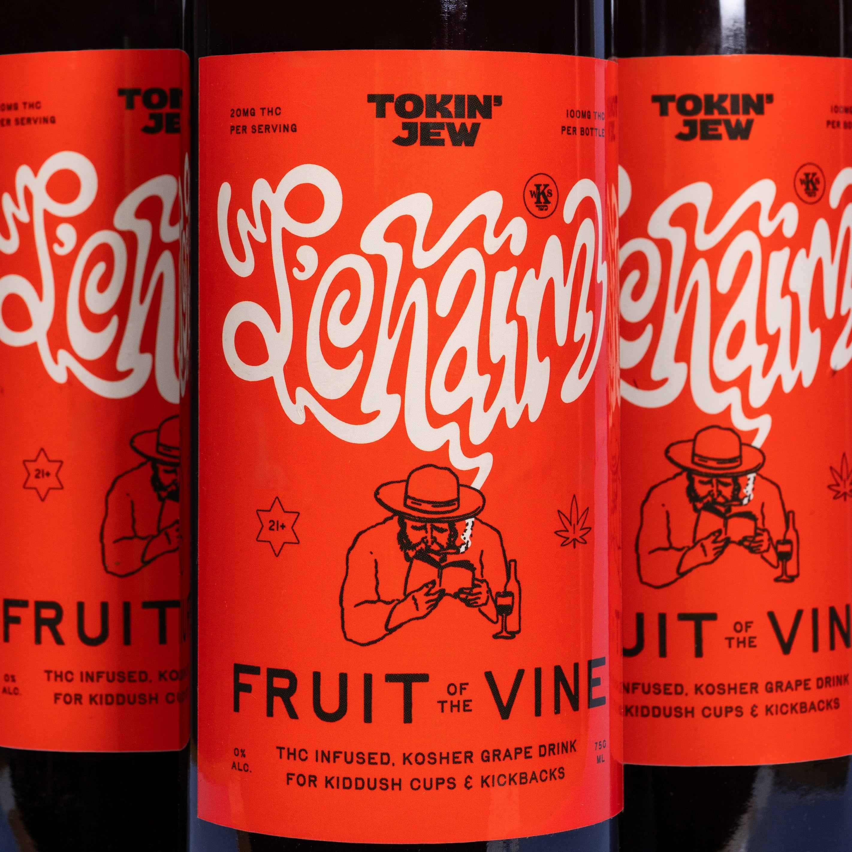 Three dark glass bottles of Tokin' Jew Fruit of the Vine kosher grape drink with bright red labels and white script lettering, shown in a close-up studio shot.