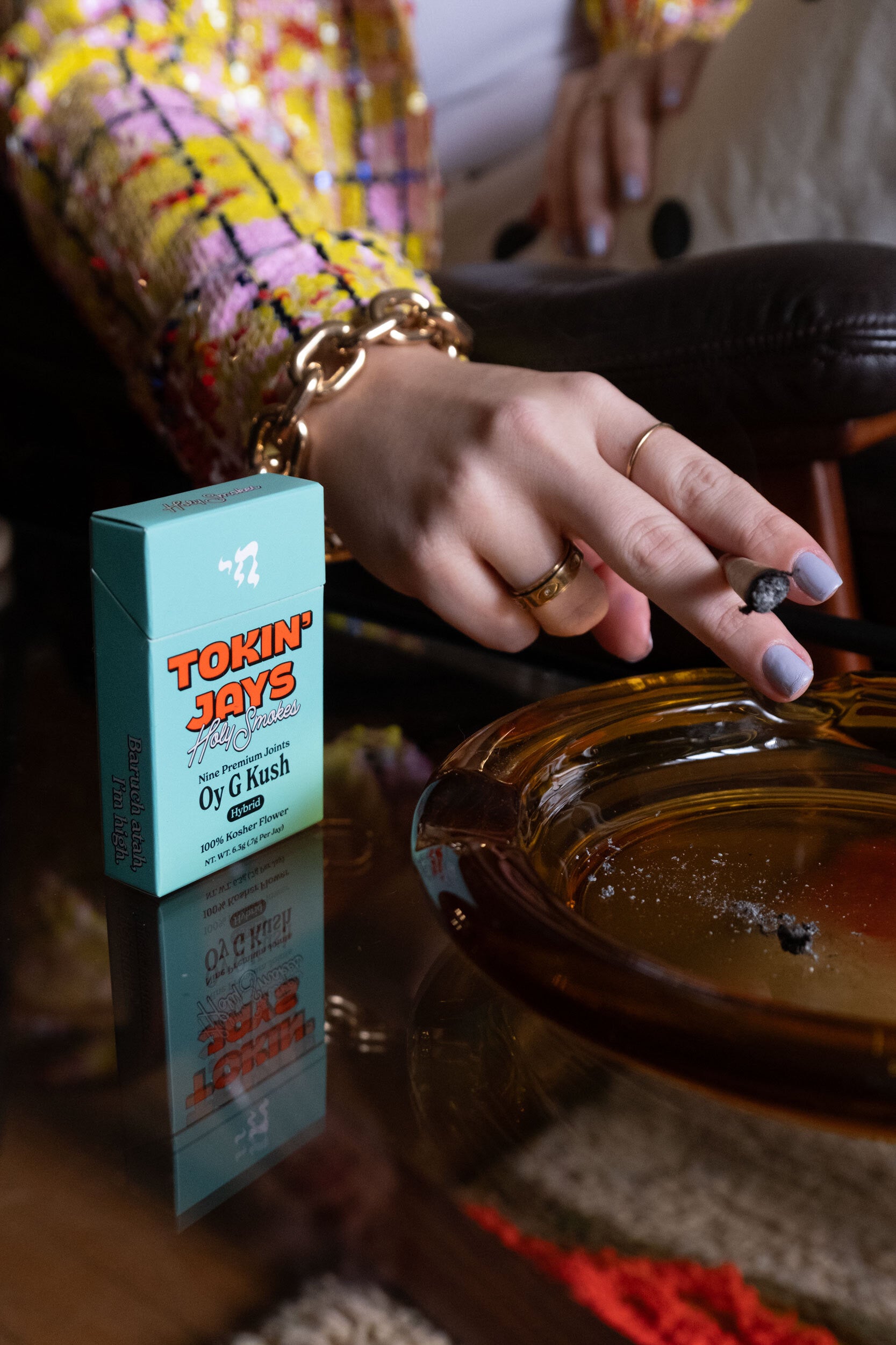 Person holding 'Tokin Jays' with an ashtray and tokin jay pack in the foreground.