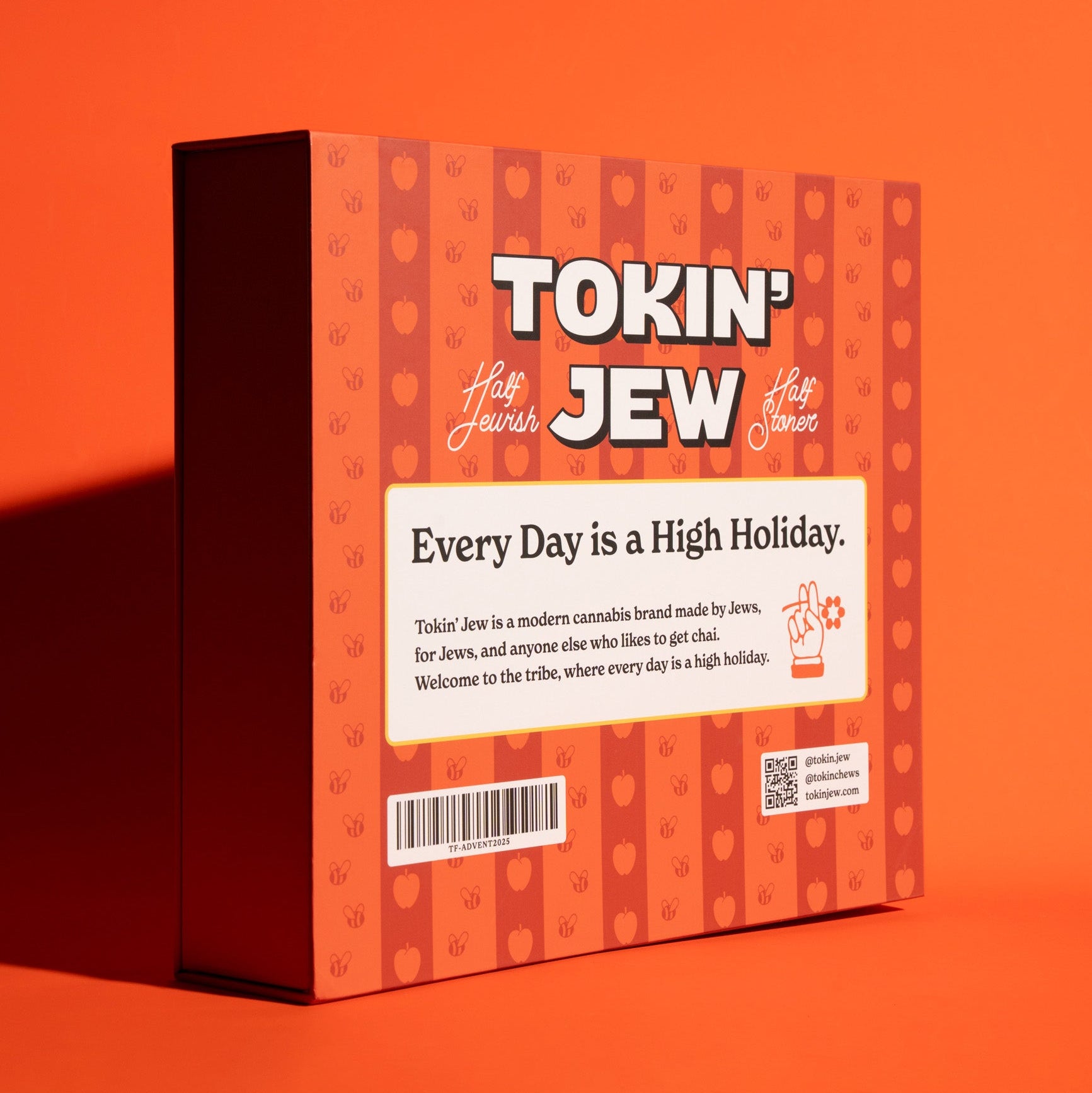 A rectangular advent calendar box standing upright on a solid orange background. The box has an orange and red patterned design with the text 'TOKIN' JEW' prominently displayed at the top, along with smaller script text and a white label in the center reading 'Every Day is a High Holiday.