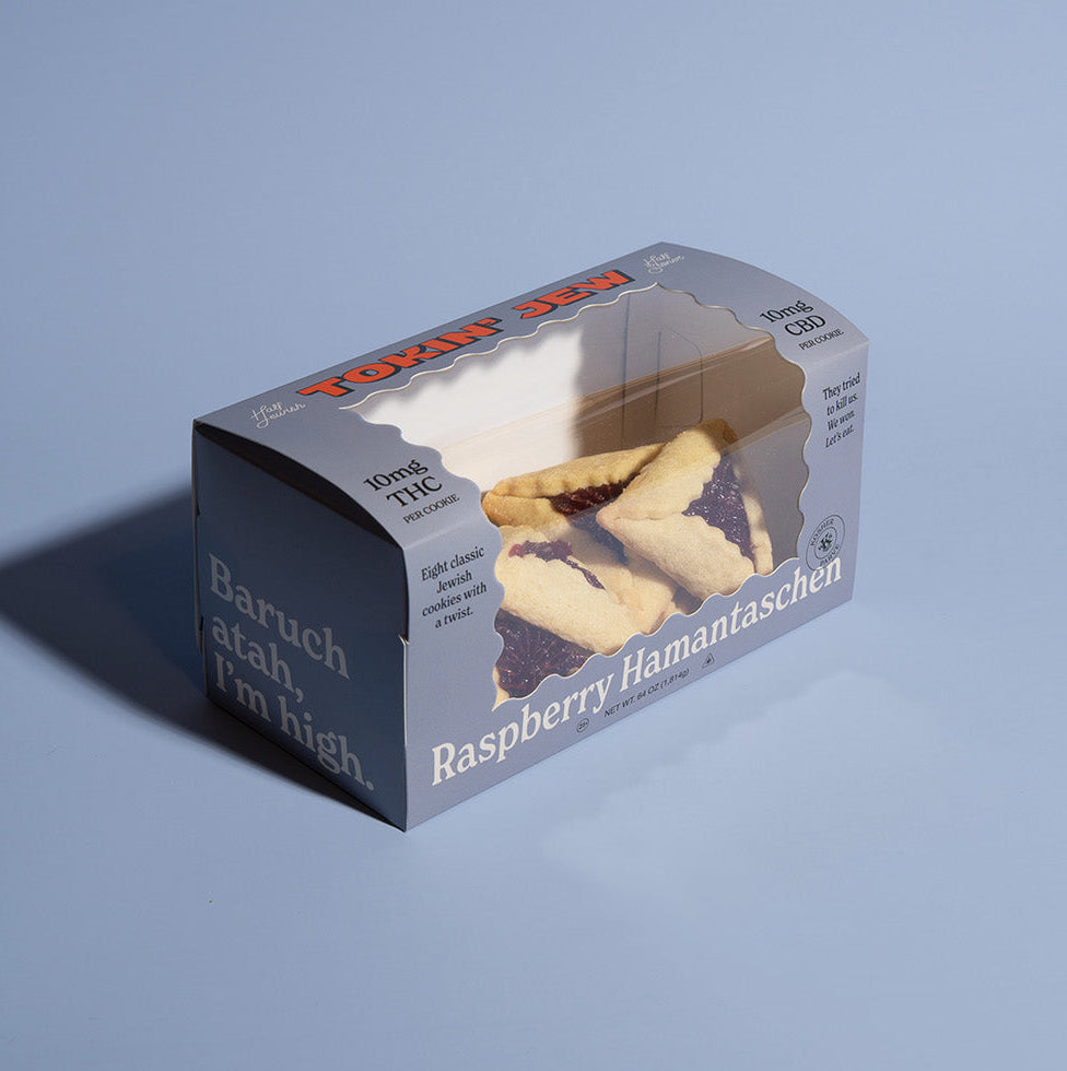 Box of raspberry hamantaschen on a blue background