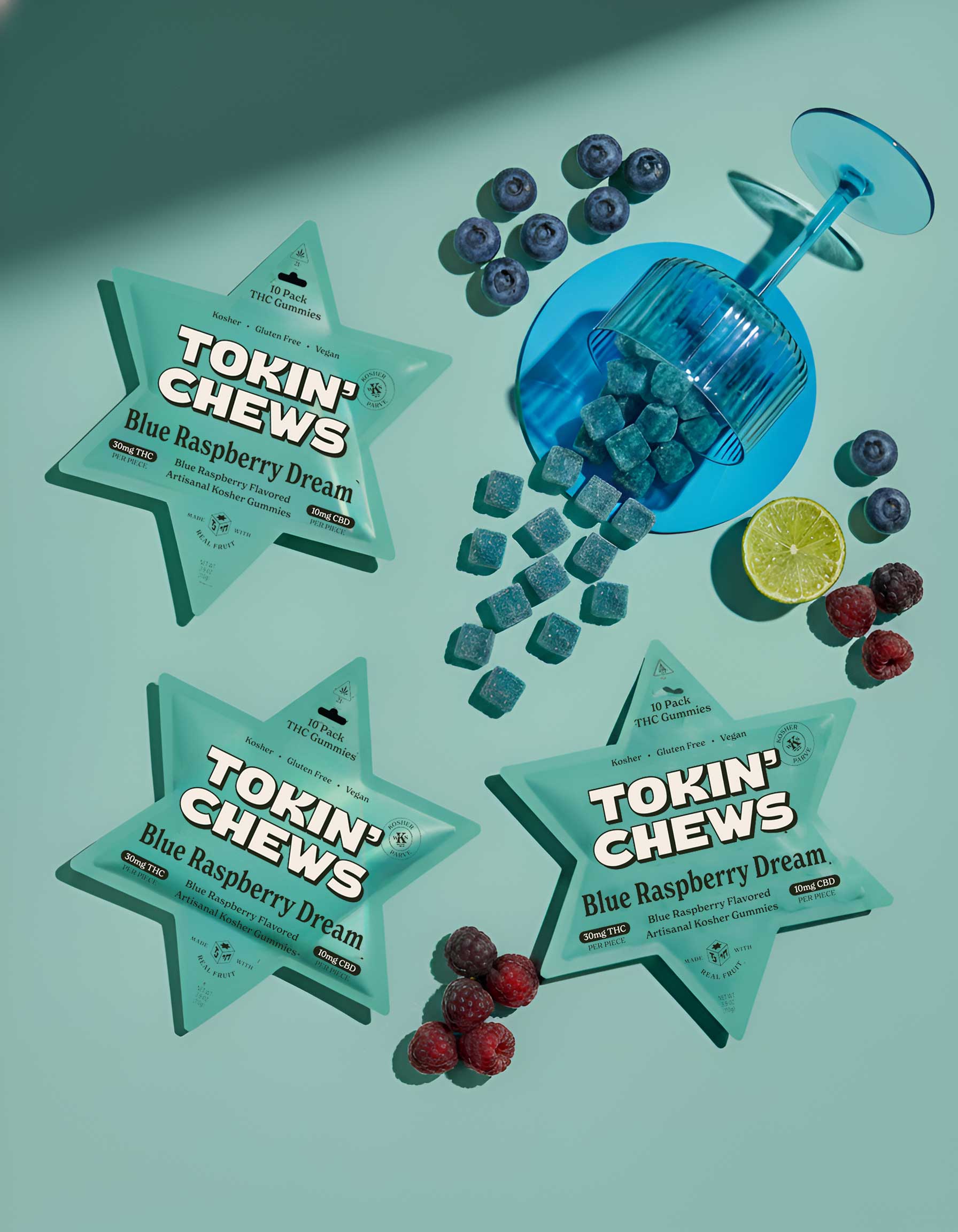 Star-shaped 'Tokin' Chews' packages with blue raspberry flavor on a light green background with berries and a blue shaker.