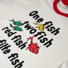 White shirt with red sleeves featuring colorful fish illustrations and text on an orange background