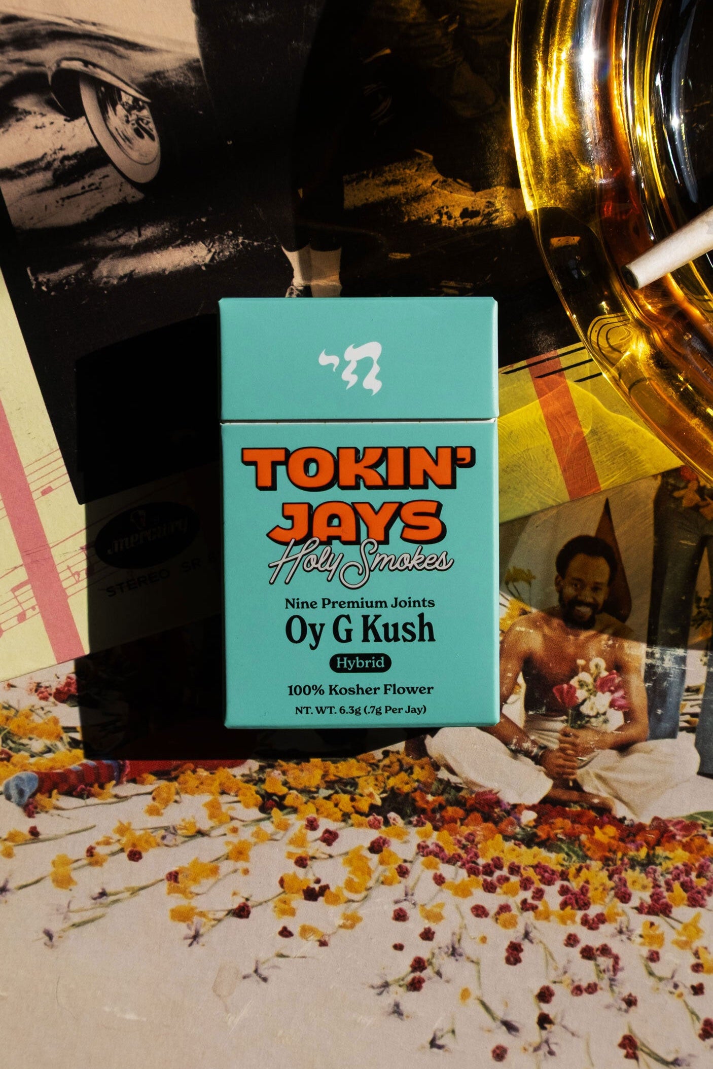Turquoise packaging of Tokin' Jays Oy G Kush with a colorful background