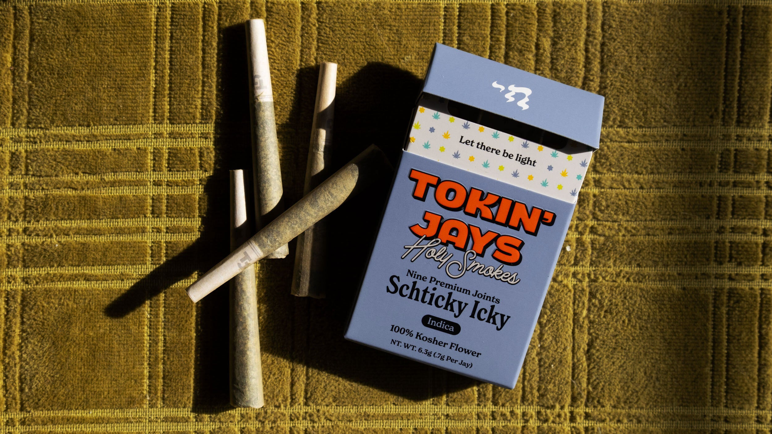 Pack of 'Tokin' Jays' with joints on a textured green surface