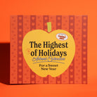 The Highest of Holidays Advent Calendars 'For a Sweet New Year' box, featuring a large yellow apple graphic in the center with black text, set against a background of red and orange vertical stripes with small apple motifs.