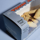 Box of hamentaschen cookies with 10mg THC per cookie on a blue background