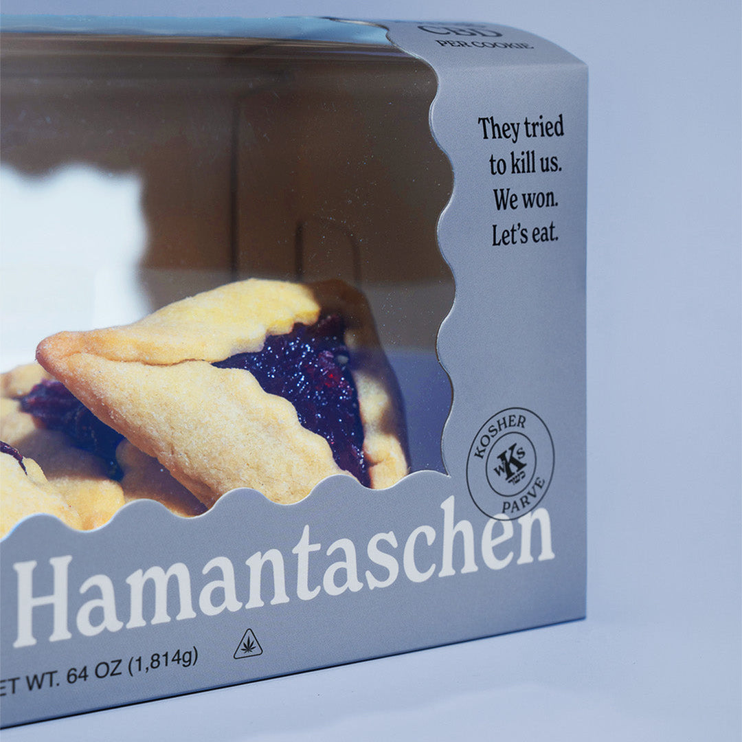 Box of Hamantaschen cookieson a light blue background