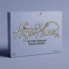 A rectangular product box for 'High Honey' 10 THC Infused Honey Sticks, featuring a light blue-gray background with elegant white and gold cursive lettering and black text, set against a matching blue-gray studio background.